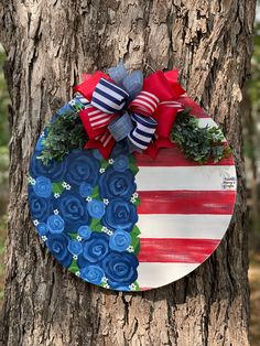 an american flag painted on a tree with red, white and blue flowers in the center