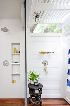 a bathroom with white walls and wooden floors