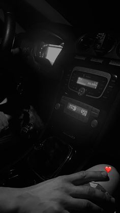 a person's hand on the steering wheel of a car with a red light