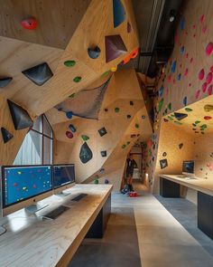 an office with climbing walls and computers on the desks, along with other workspaces