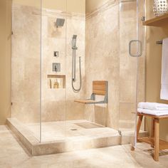 a walk in shower sitting next to a wooden bench