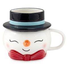 a ceramic mug with a hat and bow tie on it's head, sitting in front of a white background