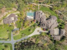 an aerial view of a large home surrounded by trees