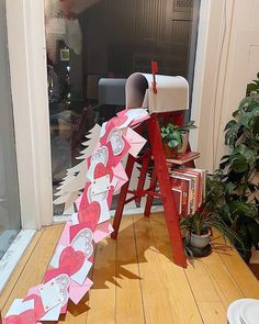 a red ladder with valentine's day decorations on it in front of a door