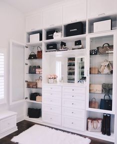 a white closet filled with lots of purses and handbags on top of shelves