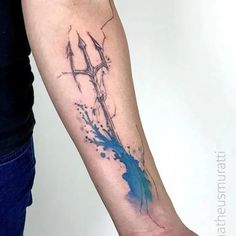 a tattoo on the arm of a person with blue ink splattered on it