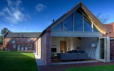 a modern house with an open living area and large windows on the front door, surrounded by green grass