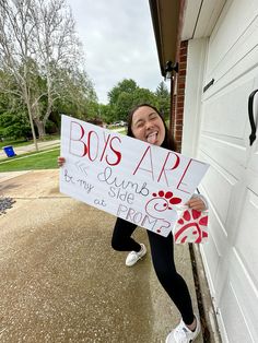 a woman holding up a sign that says boys are amazing and my spirit is pretty