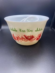 a white bowl sitting on top of a table next to a cup holder with two spoons in it