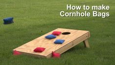 a cornhole game set up in the grass with blue and red pillows on it