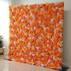 an orange and pink flowered wall in the middle of a room with white walls