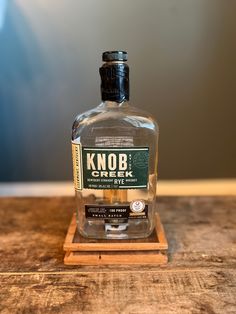 a bottle of knob creek gin on a wooden stand