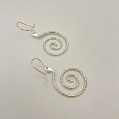 Sterling silver swirl dangle earrings with French hook wires, a unique and elegant design. Handmade by Zuni artist, Carlton Jamon. Measurements: 2" x 0.9" (including wire) Weight: 0.19oz (5.4g) Material: sterling silver (silver925) Swirl Shaped Sterling Silver Earrings For Gifts, Handmade Silver Swirl Earrings, Minimalist Sterling Silver Swirl Earrings, Silver Swirl Wire Wrapped Earrings, Unique Sterling Silver Swirl Earrings, Southwest Blankets, Sand Painting, Native American Crafts, Craft Shop