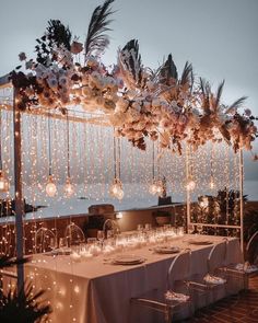 an outdoor dining area with lights and flowers