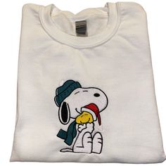 a white t - shirt with a cartoon character on the chest and a hat on its head