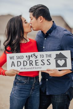 a couple kissing while holding a sign that says, we said yes to the address