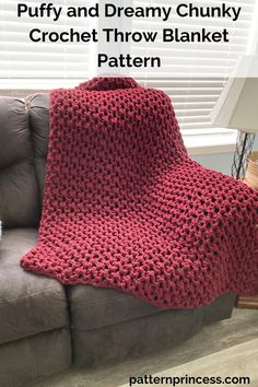 a red crocheted blanket sitting on top of a couch