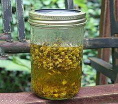 a jar filled with yellow flowers sitting on top of a wooden bench