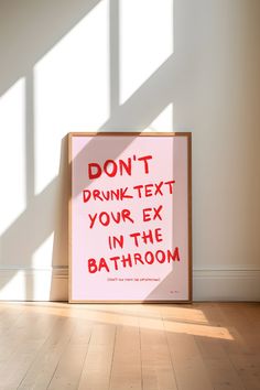 a pink sign that says don't drunk text your ex in the bathroom