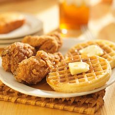 fried chicken and waffles are served on a plate with honey syrup in the background