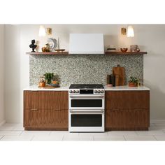 a white stove top oven sitting inside of a kitchen next to a wall mounted range