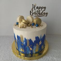 a birthday cake decorated with gold and blue decorations