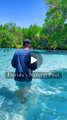 a man standing in the water with his back to the camera