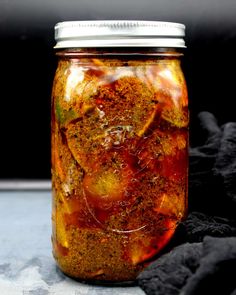 a jar filled with food sitting on top of a table next to a black cloth