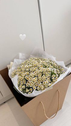 a bouquet of daisies in a brown paper bag