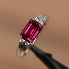 It is a lab ruby ring. The main stone is 6mm*8mm emerald cut, weight about 1.70 carats.The basic metal is sterling silver and plated with rhodium.To change the metal to a solid gold (white/rose) or platinum is also available, please ask for a quotation if you want.You can also go to my shop Home for more elegant rings: https://www.etsy.com/shop/godjewelry?ref=hdr_shop_menuRuby is the July birthstone.More ruby rings:https://www.etsy.com/shop/godjewelry?section_id=20709238Customization is always w Red Emerald Cut Birthstone Ring, Emerald Cut Red Birthstone Ring, Classic Emerald Cut Lab-created Ruby Ring, Classic Emerald-cut Lab-created Ruby Ring, Red Emerald Cut Birthstone Promise Ring, Emerald Cut Lab-created Ruby Promise Ring, Emerald Cut Ruby Ring In White Gold, Red Emerald-cut Diamond Birthstone Ring, Emerald Cut Ruby Promise Ring