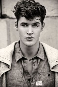 black and white photograph of a young man with short hair wearing a jacket, looking at the camera