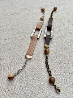 A hammered leather, supple and soft, inserted in a rectangle of bluish gray mother-of-pearl. And black stone or landscape jasper beads for roundness. A brass or silver stainless steel chain, depending on the color of the leather chosen, on either side for flexibility. Lobster type attachment. Beautiful, right? This bracelet will not leave anyone indifferent. Measures 20 to 22 cm. Leather Strap Bracelet Jewelry For Everyday, Leather Strap Bracelet For Everyday Use, Everyday Leather Strap Bracelet Jewelry, Everyday Leather Strap Bracelet, Everyday Leather Bracelet Jewelry, Brown Rectangular Metal Jewelry, Brown Rectangular Bohemian Bracelet, Brown Bohemian Rectangular Bracelet, Rectangular Brown Metal Jewelry