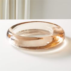 an empty glass bowl sitting on top of a white table