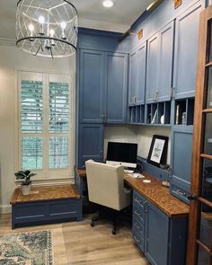 a home office with blue cabinets and a desk