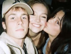 two girls and a boy are posing for the camera with their heads close to each other