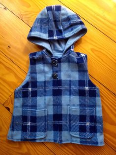 Toddler fleece vest in blue plaid, lined with warm cotton flannel. Button closure with loops and pockets. All fabric is pre-washed and put through a dryer for less shrinkage. Please refer to size chart as the vest is made to wear over a sweater. Please custom order if your child needs a different size. 🎁 Giftwrap option available! Blue Buttoned Vest For Fall, Blue Sleeveless Outerwear With Buttons, Winter Blue Flannel Outerwear, Blue Cotton Vest For Fall, Plaid Cotton Vest For Fall, Fall Plaid Cotton Vest, Boys Tops, Fleece Vest, Cotton Flannel