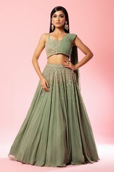 Sage green lehenga with attached cancan and cutdana, sequin, thread, bead embroidery in flower pattern. Paired with draped  padded blouse.
Components: 2
Pattern: Embroidery
Type Of Work: Cutdana, sequin, thread, bead, floral
Neckline: Sweetheart neck
Sleeve Type: Sleeveless
Fabric: Georgette
Color: Green
Other Details: 
Approx Weight: 3kg
Attached drape
Flared hem
Occasion: Destination Wedding - Aza Fashions Green Bridesmaid Lehenga, Sage Green Lehenga, Drape Dupatta, Draped Lehenga, Off Shoulder Lehenga, Royal Blue Lehenga, Drape Lehenga, Strappy Blouse, Rich Outfits