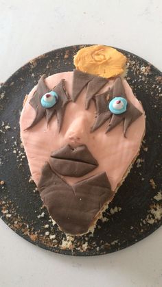 a cake that has been decorated to look like a man's face with blue eyes