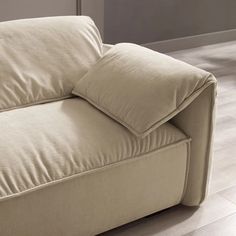 a beige couch with two pillows on it