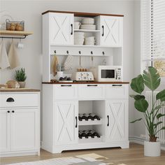 a kitchen with white cupboards and wooden flooring, including a potted plant