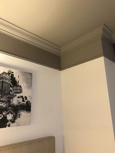 a black and white photo hanging on the wall next to a bed with a headboard