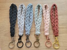 four crocheted lanyards are lined up on a table with metal handles