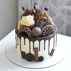 a chocolate cake with white frosting and lots of candy on top, sitting on a table