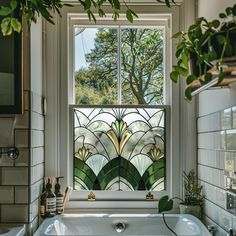 a bath tub sitting under a window next to a sink in a room with tiled walls