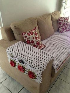 a crocheted couch with pillows on it and a blanket draped over the back