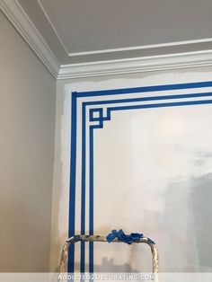 a ladder is painted blue and white in a room that has been stripped off with tape