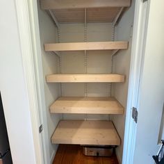 an empty closet with shelves in it and hard wood flooring on the other side