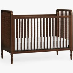 a wooden crib with white sheets in it