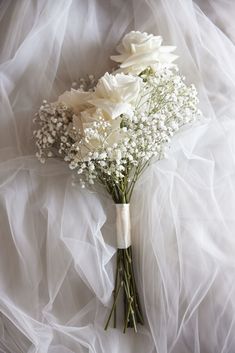 a bouquet of white flowers sitting on top of a bed