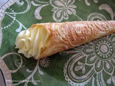 a pastry on a green plate with white icing and some sort of cream in it